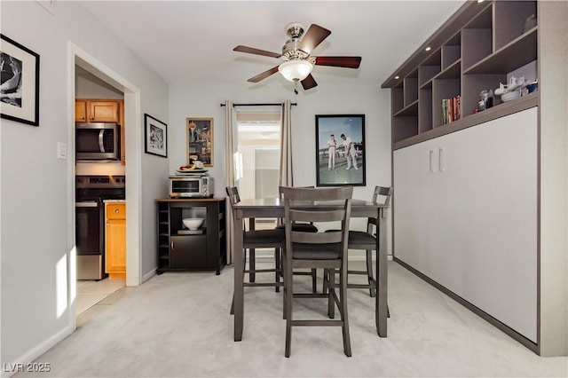 dining space featuring ceiling fan, baseboards, light carpet, and a toaster