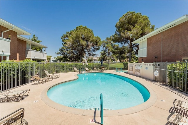 pool with a patio and fence