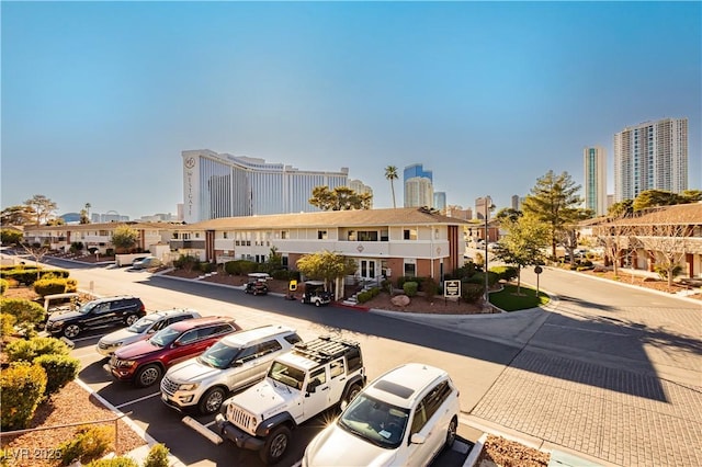 view of building exterior featuring uncovered parking and a city view