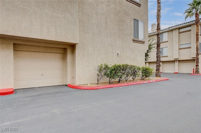 exterior space with an attached garage and stucco siding