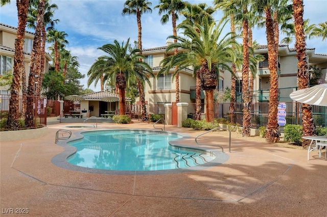 pool with a patio area and fence