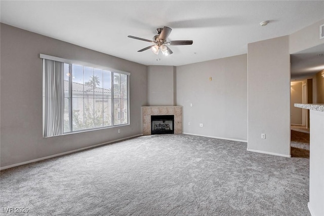 unfurnished living room featuring ceiling fan, a fireplace, baseboards, and carpet flooring