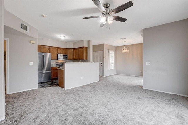 kitchen featuring appliances with stainless steel finishes, open floor plan, light carpet, and brown cabinets