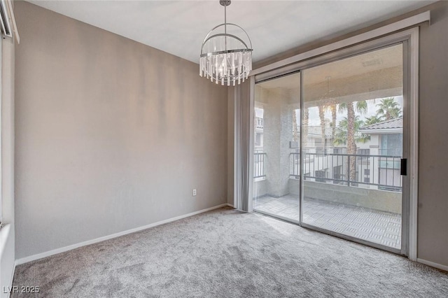 empty room with carpet, baseboards, and a notable chandelier