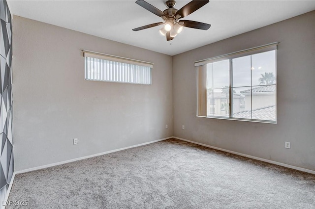 carpeted empty room featuring plenty of natural light, a ceiling fan, and baseboards