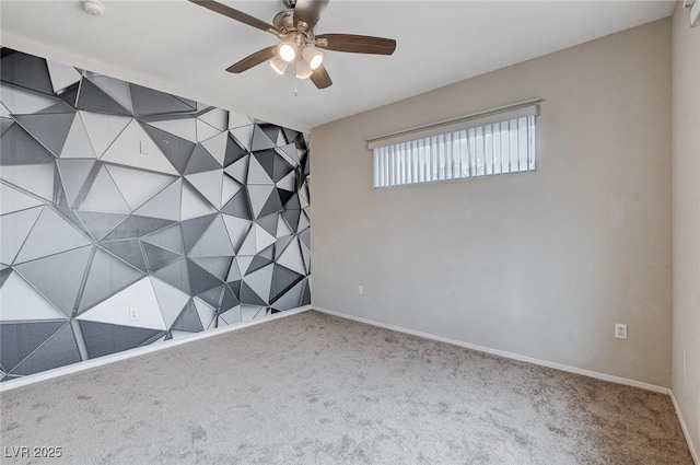 carpeted empty room with ceiling fan and baseboards