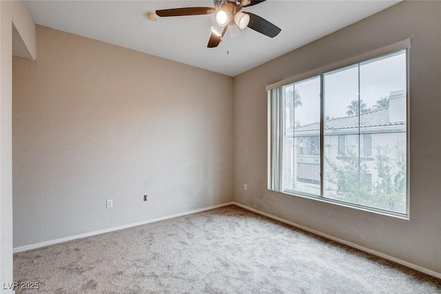 carpeted empty room featuring baseboards and a ceiling fan