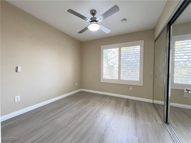 unfurnished bedroom featuring a closet, ceiling fan, baseboards, and wood finished floors