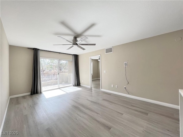 unfurnished room with ceiling fan, a textured ceiling, light wood-style flooring, visible vents, and baseboards