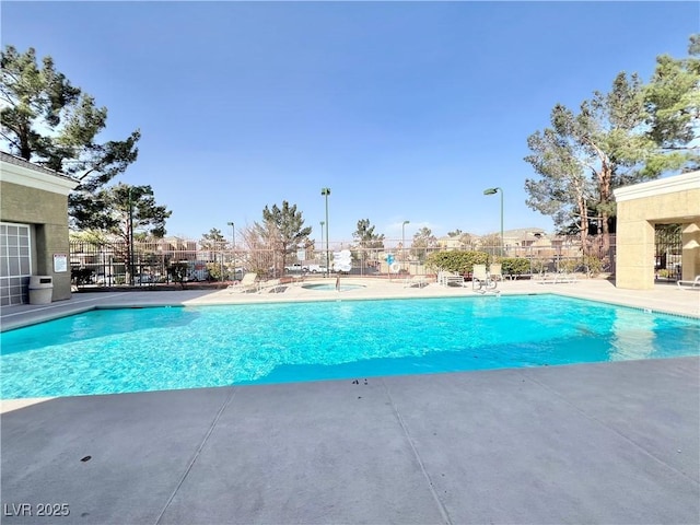 community pool featuring a patio and fence