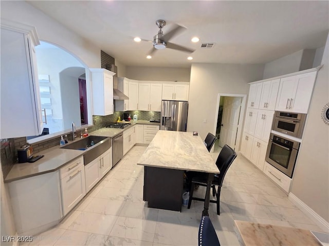 kitchen with marble finish floor, a sink, recessed lighting, stainless steel appliances, and decorative backsplash