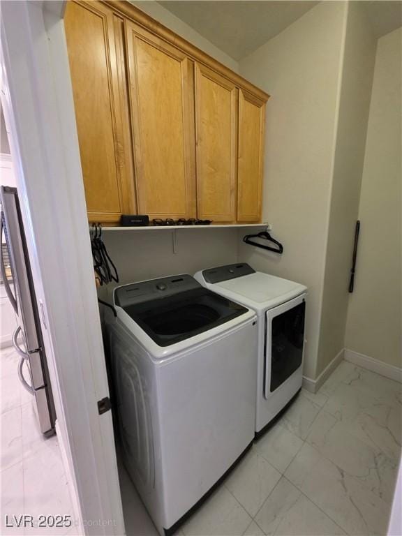 washroom featuring baseboards, cabinet space, marble finish floor, and washing machine and clothes dryer