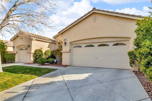 mediterranean / spanish-style house featuring concrete driveway, a garage, a tile roof, and stucco siding