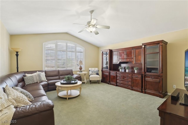 living area with a ceiling fan, carpet, vaulted ceiling, and baseboards