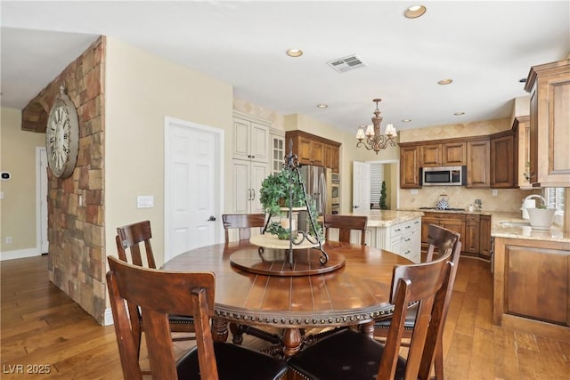 dining space featuring baseboards, visible vents, dark wood-type flooring, a chandelier, and recessed lighting