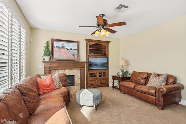 living area with baseboards, visible vents, a ceiling fan, carpet flooring, and a fireplace