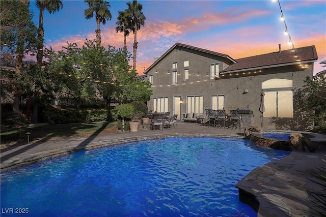 view of pool featuring a patio and a pool with connected hot tub