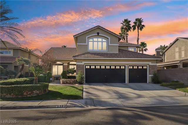 traditional-style home with concrete driveway, fence, and stucco siding