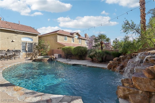 view of pool featuring a pool with connected hot tub, a fenced backyard, and a patio