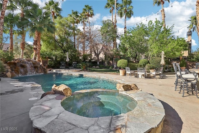 view of swimming pool with a pool with connected hot tub and a patio area