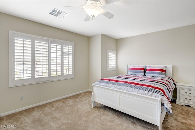 carpeted bedroom with baseboards, visible vents, and a ceiling fan