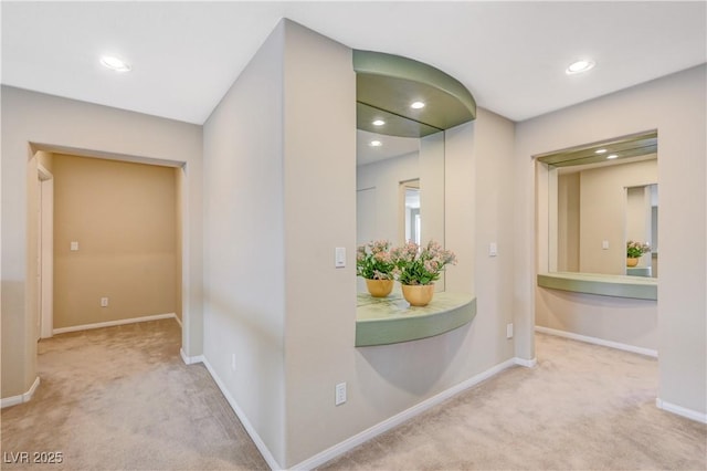 hall with carpet floors, baseboards, and recessed lighting