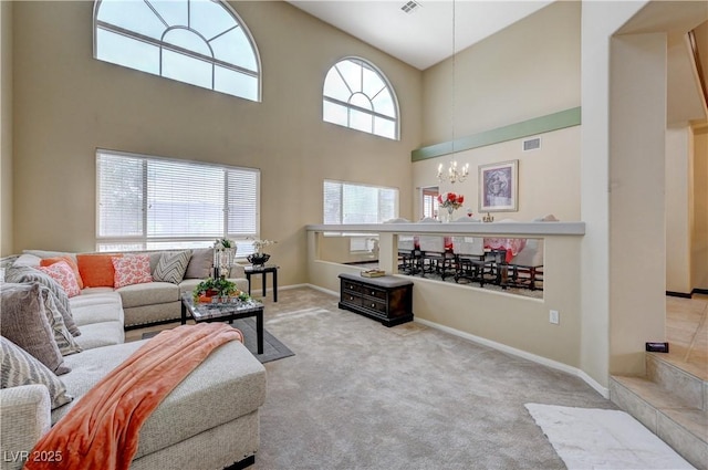 living area featuring a notable chandelier, a high ceiling, carpet flooring, visible vents, and baseboards