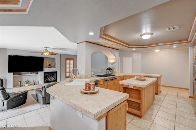 kitchen featuring open floor plan, visible vents, a sink, and a peninsula