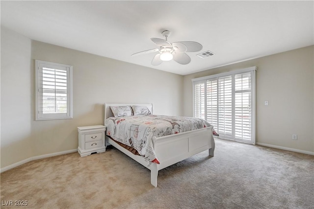 bedroom with light carpet, multiple windows, visible vents, and a ceiling fan