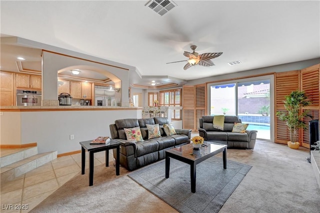 living room featuring light tile patterned flooring, visible vents, and light colored carpet