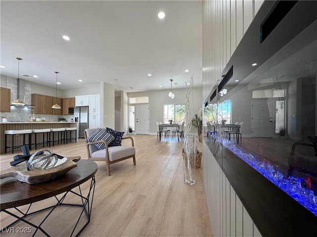 living room with recessed lighting, baseboards, and light wood-style floors