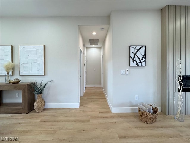 hallway with visible vents, baseboards, and wood finished floors