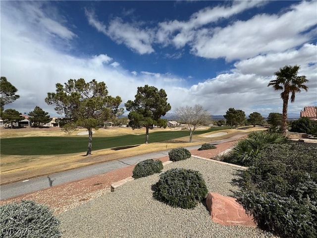 view of home's community featuring view of golf course and a lawn