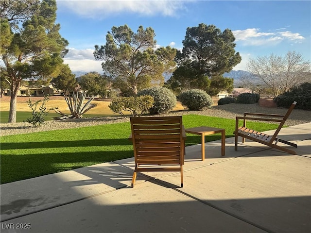 view of property's community with a yard, a patio area, and a mountain view