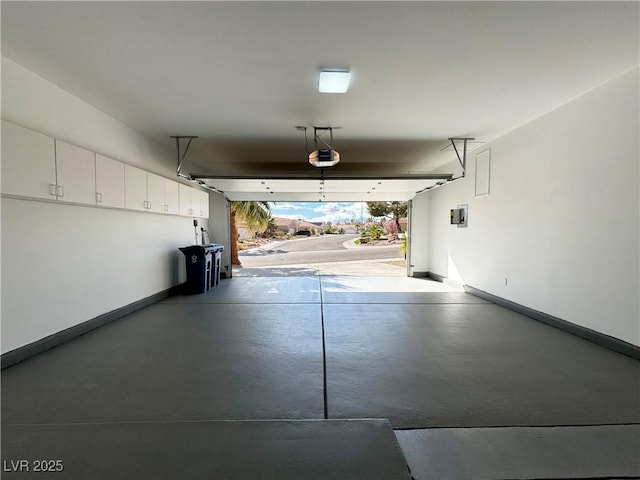 garage with baseboards and a garage door opener