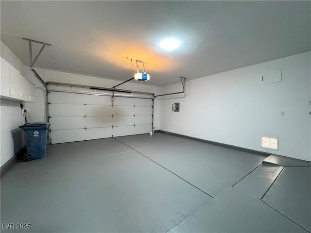 garage with electric panel, baseboards, and a garage door opener