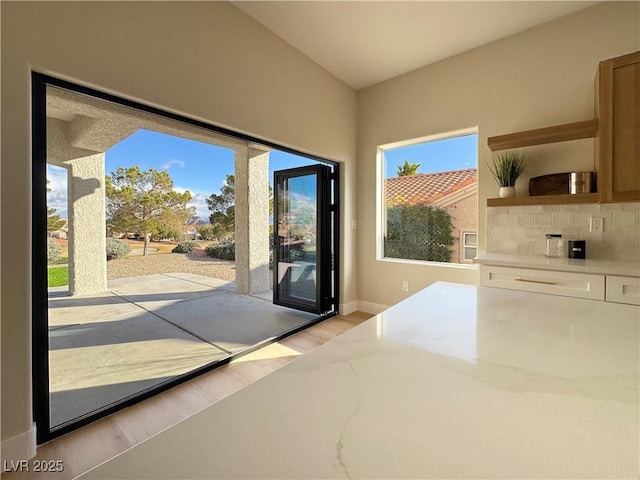 doorway featuring light wood-style flooring and baseboards