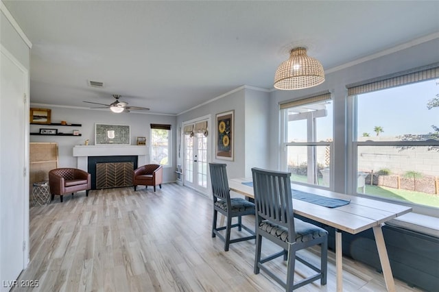 dining area featuring a fireplace, visible vents, ornamental molding, and french doors