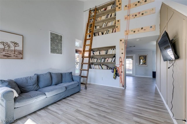 living room featuring baseboards, a high ceiling, and wood finished floors