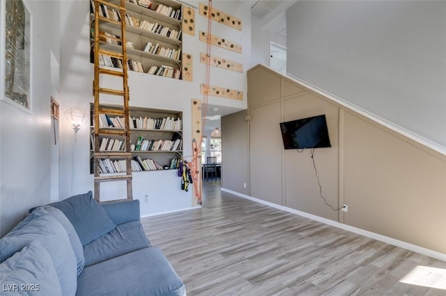 living area with a high ceiling and wood finished floors