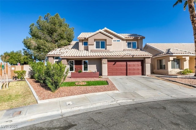 view of front facade with driveway, a garage, a tile roof, fence, and stucco siding