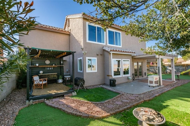 rear view of property with a tile roof, a patio, stucco siding, fence, and a pergola