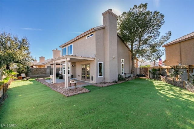 back of property featuring a fenced backyard, a lawn, a chimney, and stucco siding