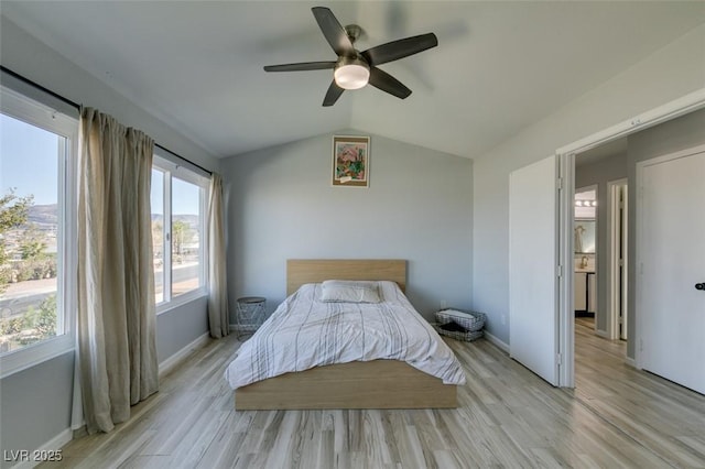 bedroom featuring light wood-style floors, lofted ceiling, baseboards, and a ceiling fan