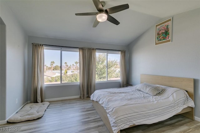 bedroom with lofted ceiling, wood finished floors, a ceiling fan, and baseboards