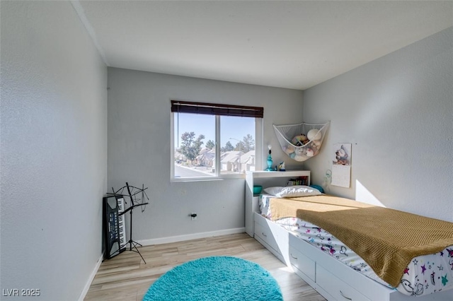 bedroom with light wood-style floors and baseboards