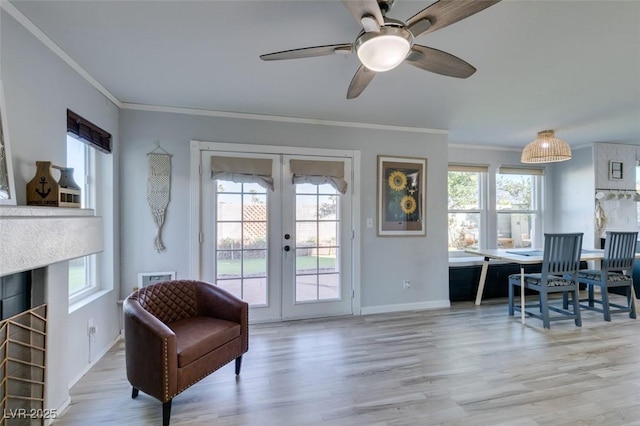 sitting room featuring ornamental molding, french doors, light wood-style floors, and a healthy amount of sunlight