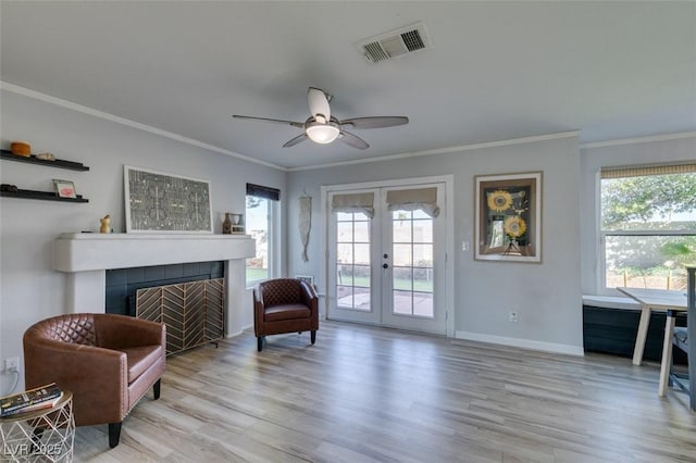 sitting room with french doors, a fireplace, visible vents, light wood-type flooring, and baseboards