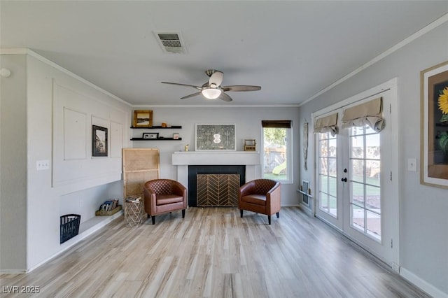 living area featuring french doors, visible vents, crown molding, and wood finished floors