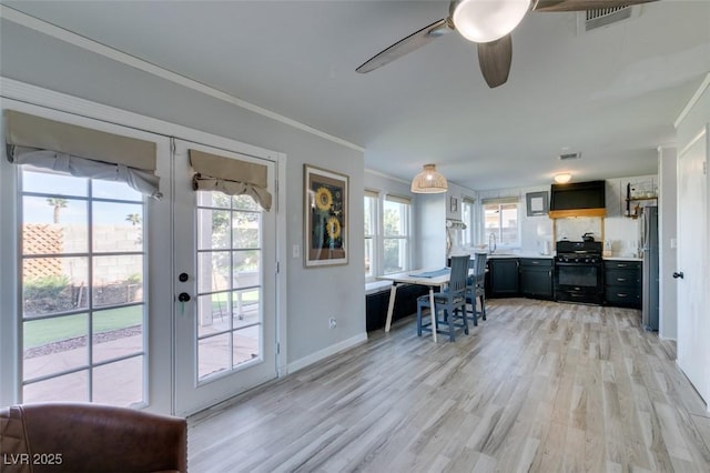 entryway featuring baseboards, light wood-style flooring, ornamental molding, french doors, and a sink